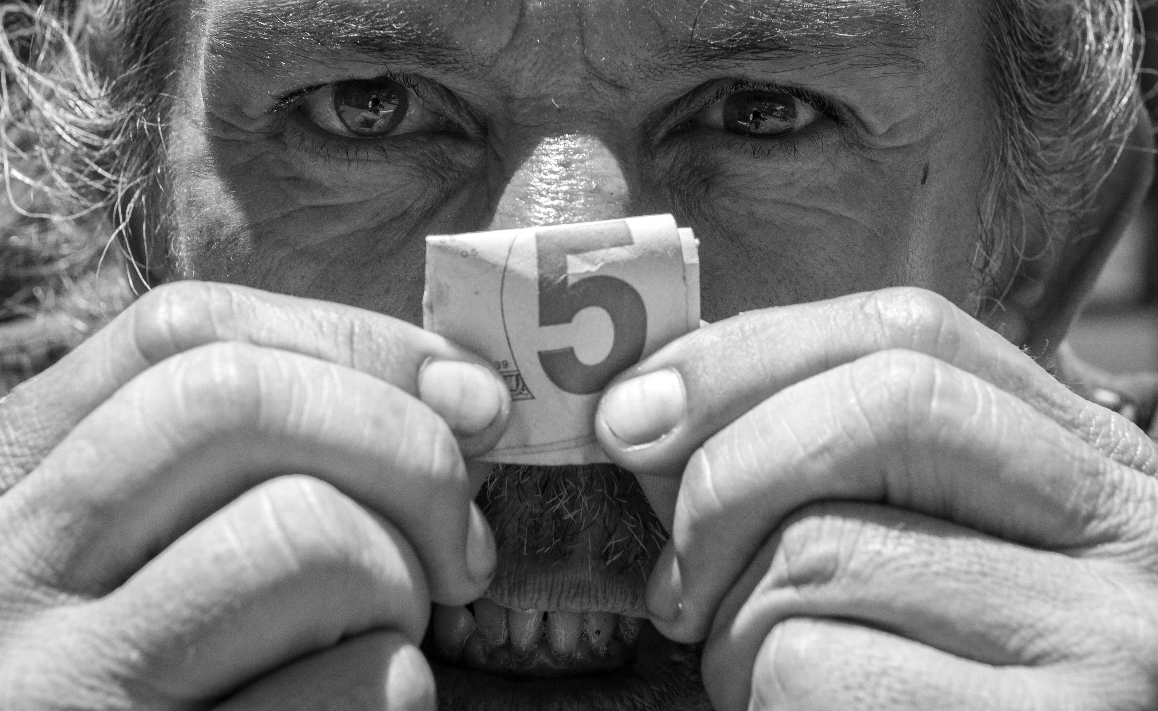 A homeless Army veteran shows a folded-up five-dollar bill prior to entering a convenience store in the Chinatown District of Honolulu, Hawaii, in 2016.